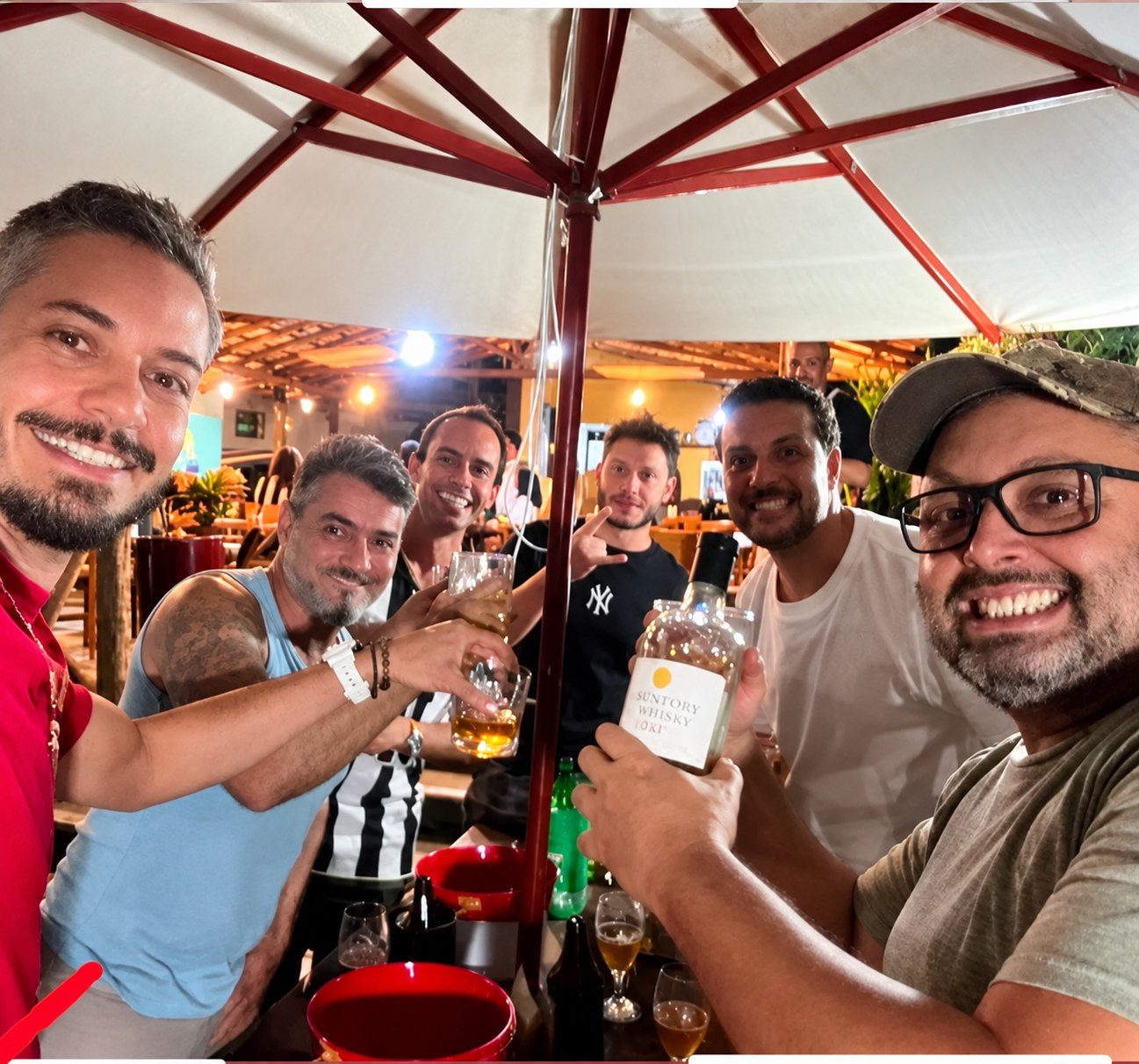 Grupo de amigos reunido sob o guarda-sol